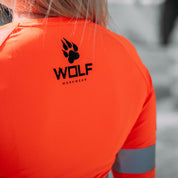 Up Close photo showcasing the detail on the back of an orange long sleeve high visibility Wolf Workwear shirt, with the logo.