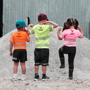 Three kids standing in industrial yard facing the other way, with high visibility Wolf t-shirts on