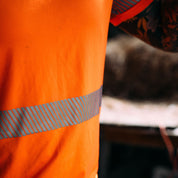 Close up of men's high visibility orange t-shirt and reflective strip