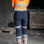 Woman standing with back to the camera, showcasing the detail on the workpants.