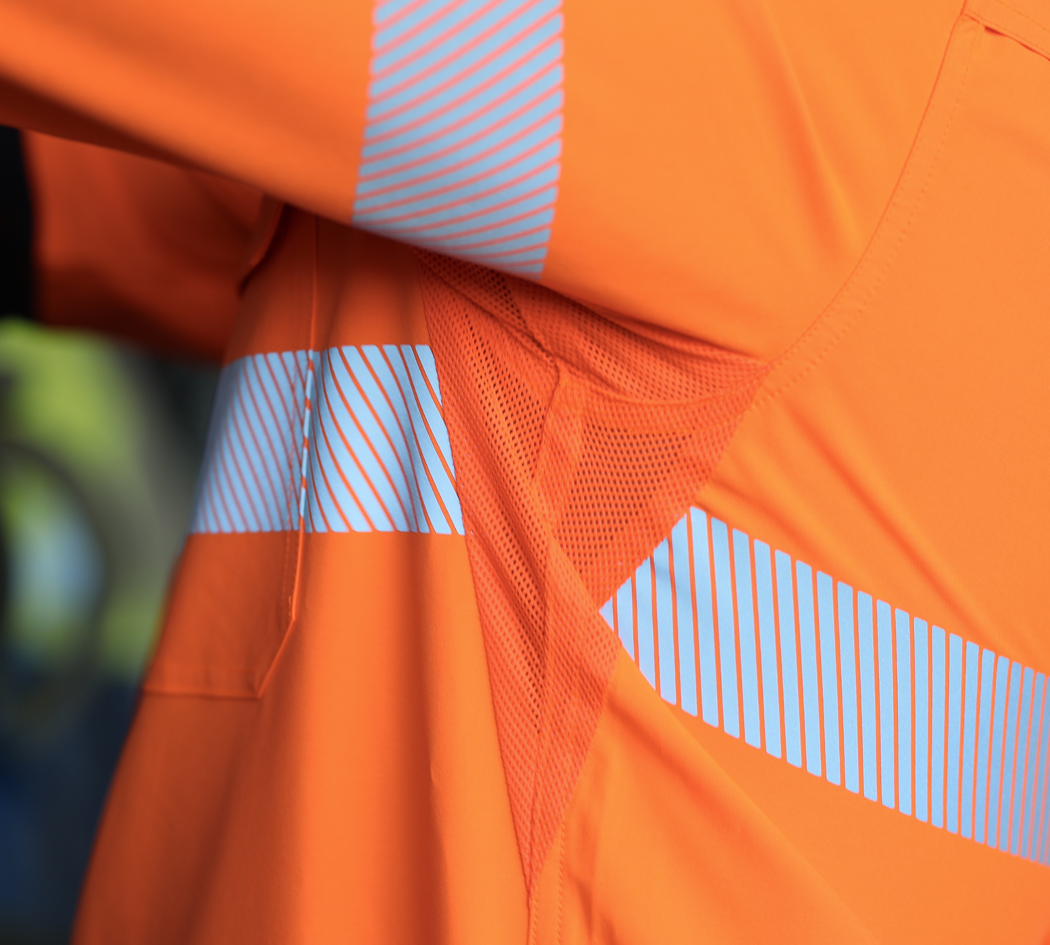 Close-up of underarm ventilation on an orange safety work shirt with reflective stripes
