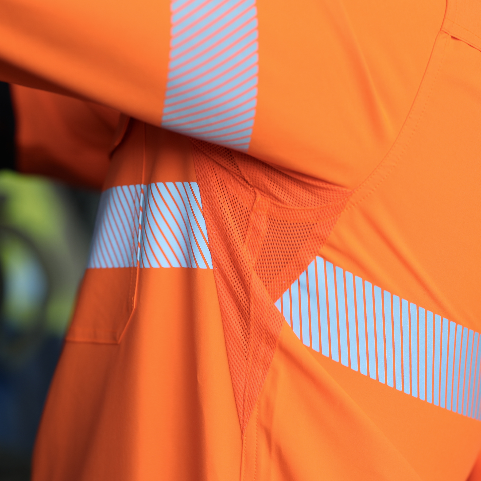 Close-up of underarm ventilation on an orange safety work shirt with reflective stripes