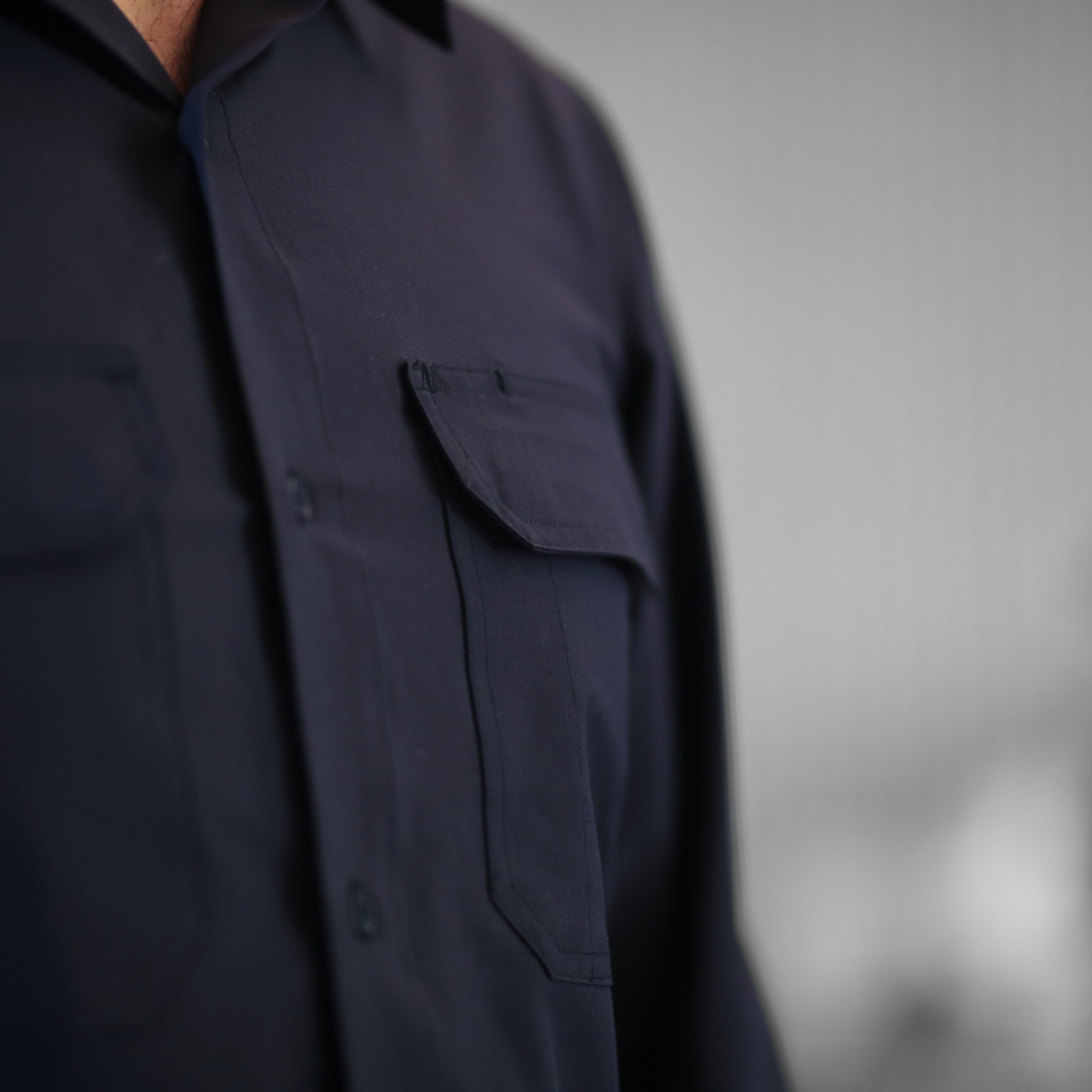 Navy blue shirt with a pocket on a gray background